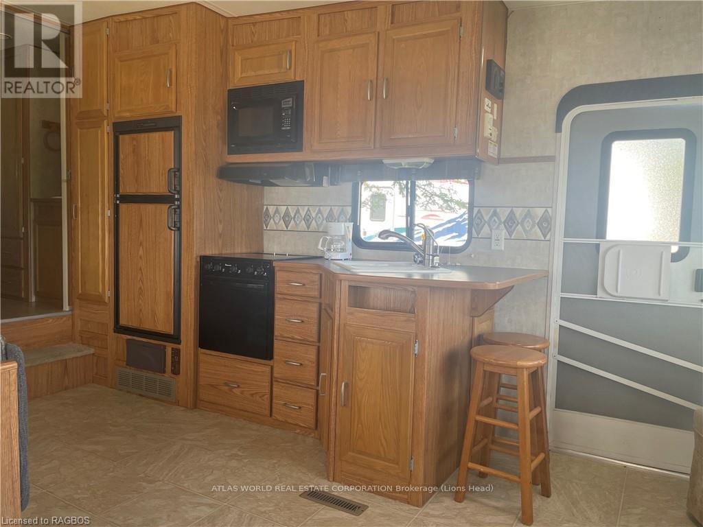A kitchen with wooden cabinets and a black oven.