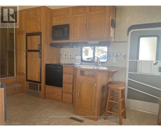 A kitchen with wooden cabinets and a black oven.
