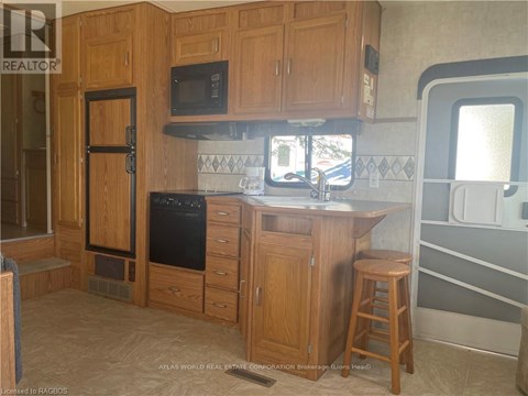 A kitchen with wooden cabinets and a black oven.