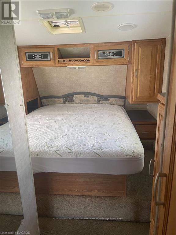 A bedroom with a bed, cupboard and a door.