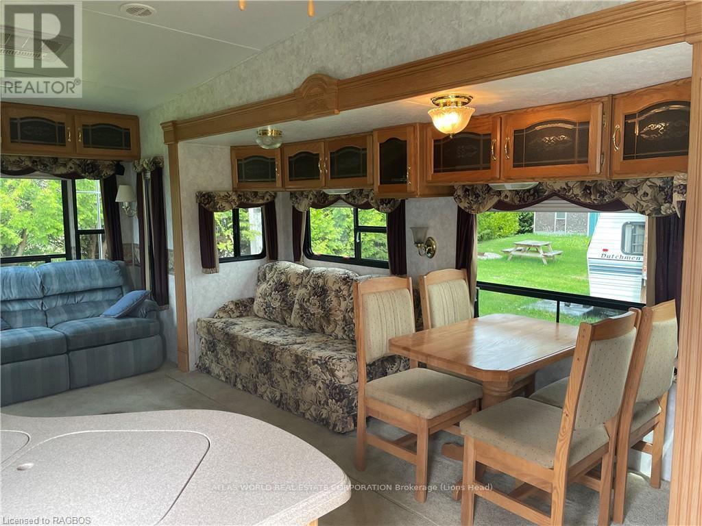A living room with a couch, chairs, and a dining table.