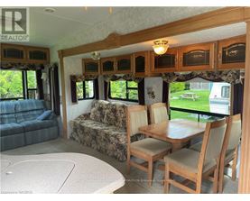 A living room with a couch, chairs, and a dining table.