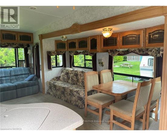 A living room with a couch, chairs, and a dining table.