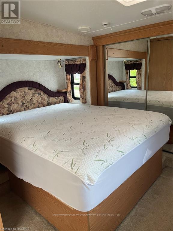 A bedroom with a bed and a mirror on the wall.
