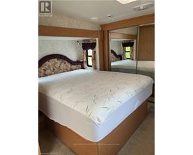 A bedroom with a bed and a mirror on the wall.