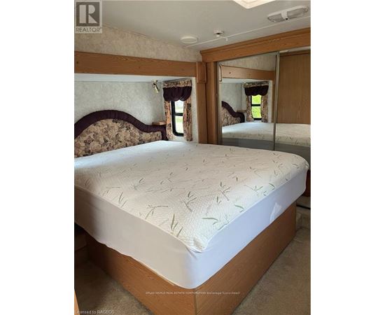 A bedroom with a bed and a mirror on the wall.
