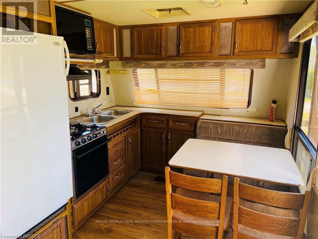 A kitchen with wooden cabinets and a white fridge.
