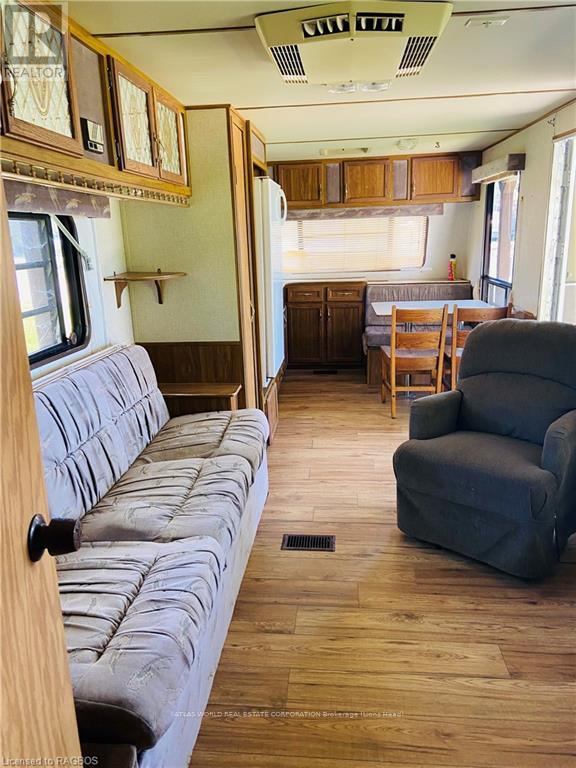 A grey couch is in the middle of a room with wooden floors and furniture.
