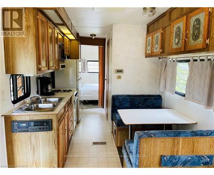 A kitchen area with a sink, stove and refrigerator.