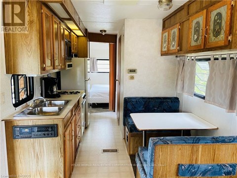 A kitchen area with a sink, stove and refrigerator.