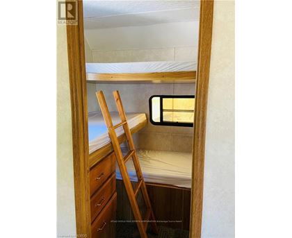 A small bedroom with a bunk bed and a ladder.