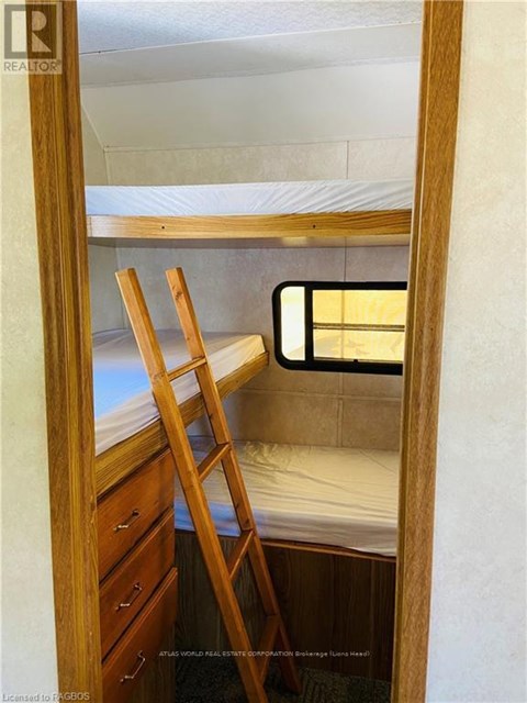 A small bedroom with a bunk bed and a ladder.