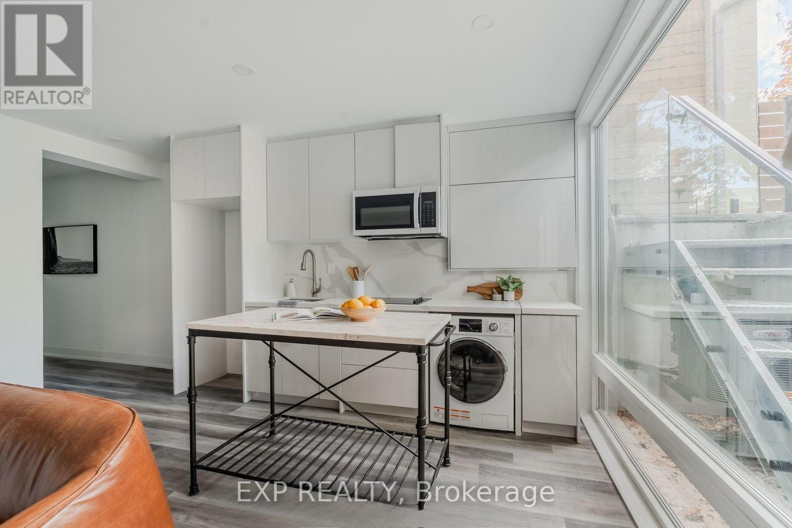 A modern kitchen with a dining table and a washing machine.