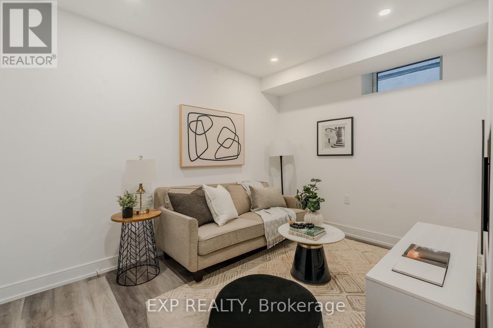 A living room with a couch, a small table, and a painting on the wall.