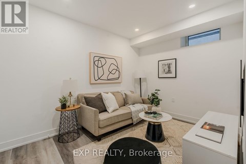A living room with a couch, a small table, and a painting on the wall.