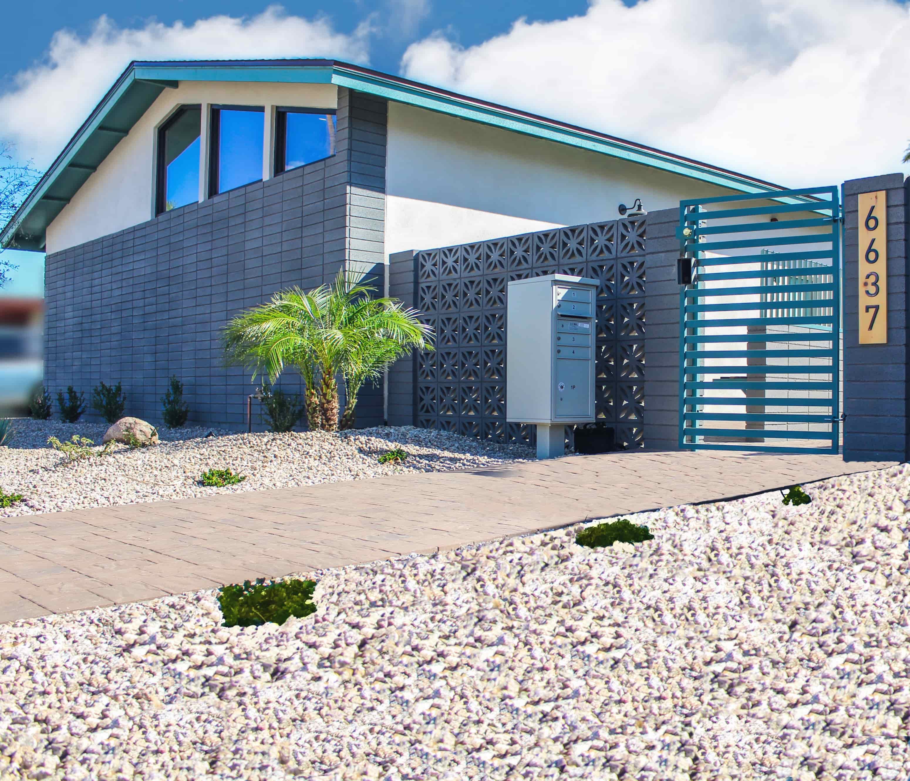A modern house with a palm tree in front.