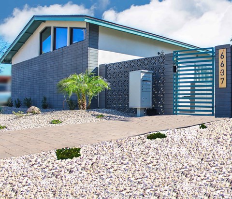 A modern house with a palm tree in front.