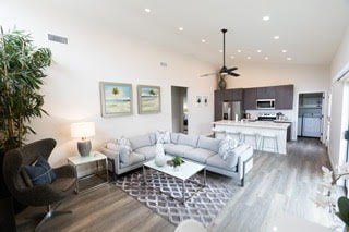 A modern living room with a grey and white color scheme.