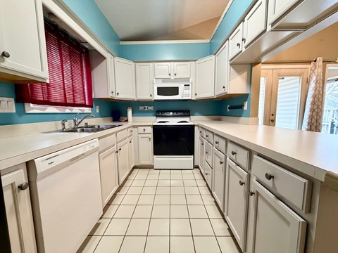 A kitchen with white cabinets and a black stove top oven.