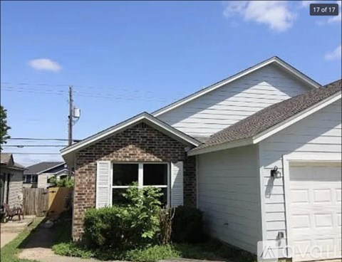 A house with a white garage door and a brick chimney.