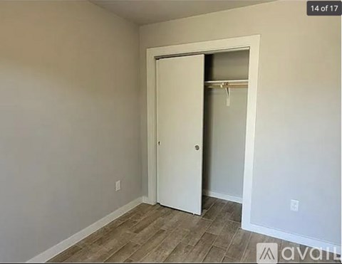 A room with a white door and a wooden floor.