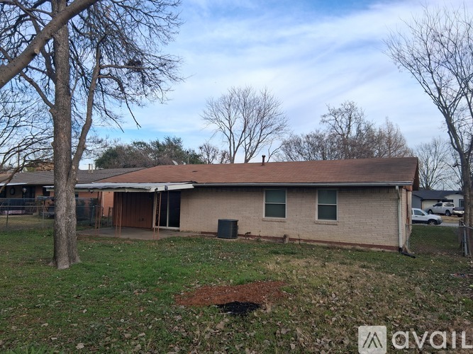 A house with a brown roof and a green lawn in front.