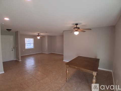 A room with a ceiling fan and a table in it.