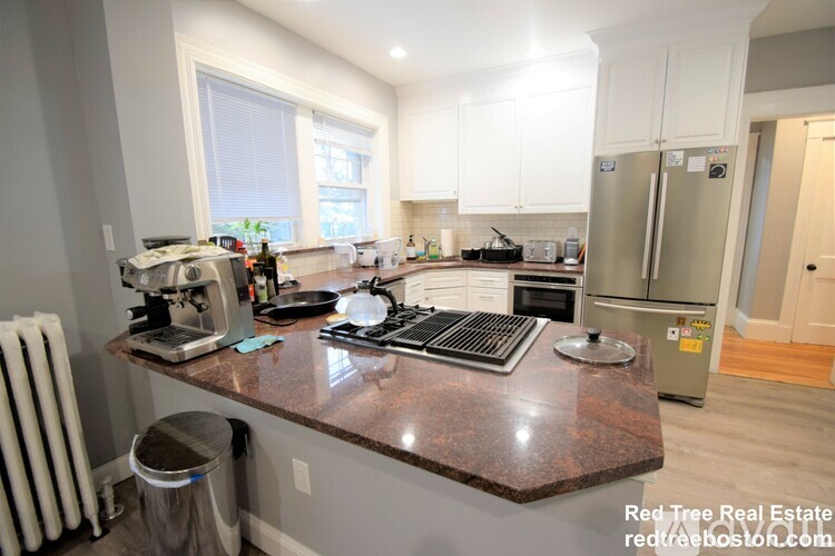 A kitchen with a granite countertop and stainless steel appliances.