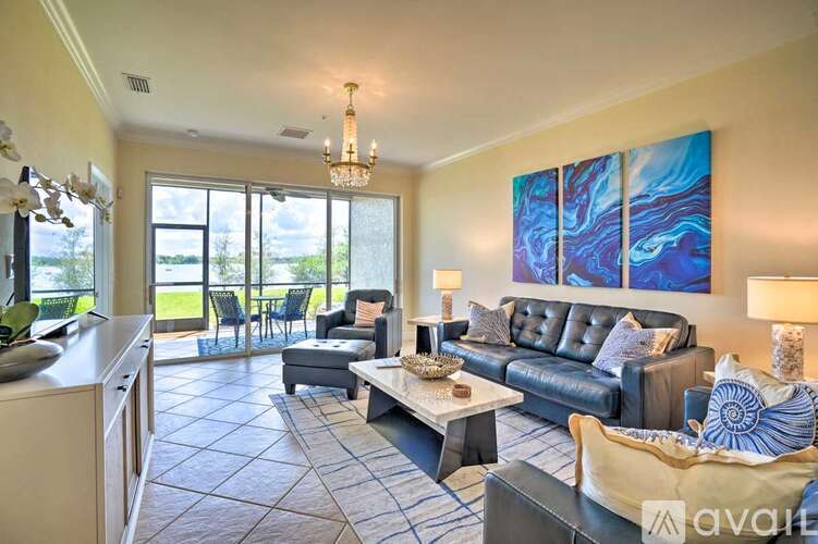 A living room with a large painting on the wall and a dining table with chairs.