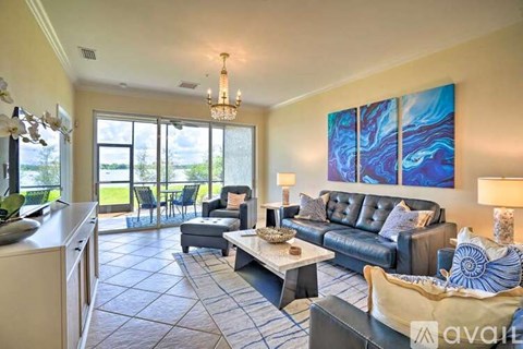 A living room with a large painting on the wall and a dining table with chairs.