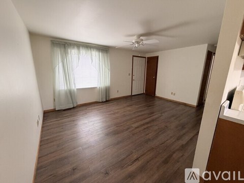 A room with wooden flooring and a ceiling fan.