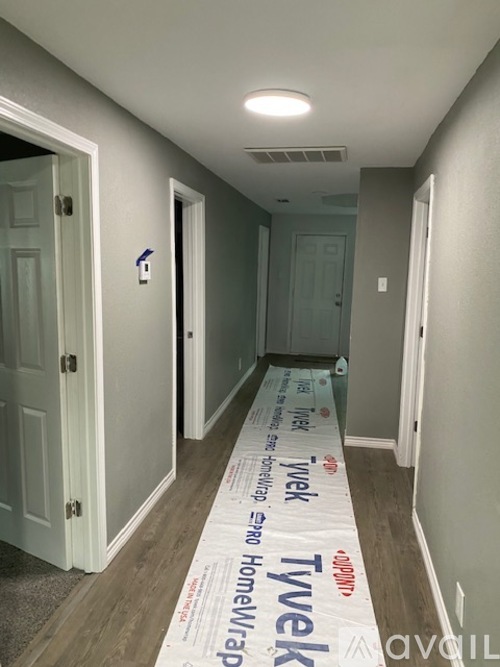 A hallway with Tyvek house wrap on the floor.