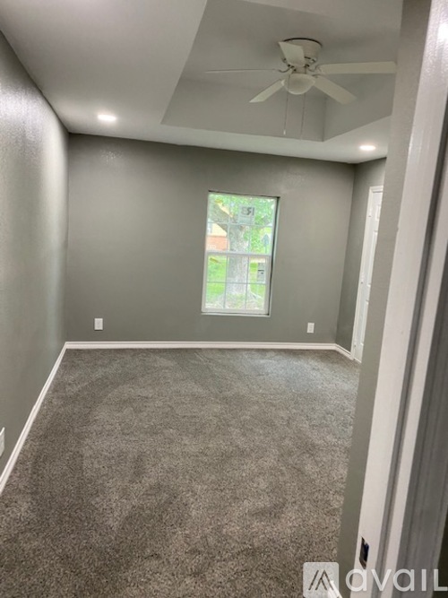 A room with a ceiling fan and carpeted floor.