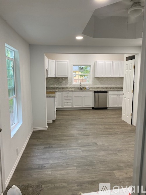 A kitchen with white cabinets and a marble countertop.