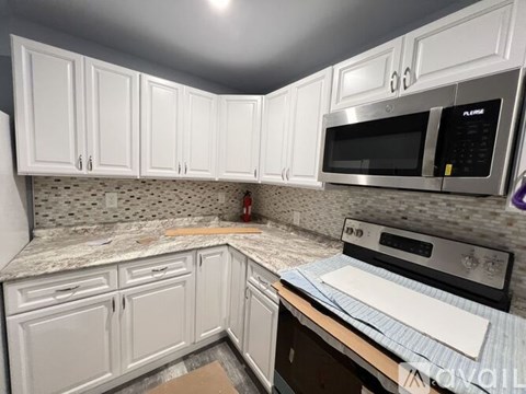 A kitchen with white cabinets and a microwave above the stove.