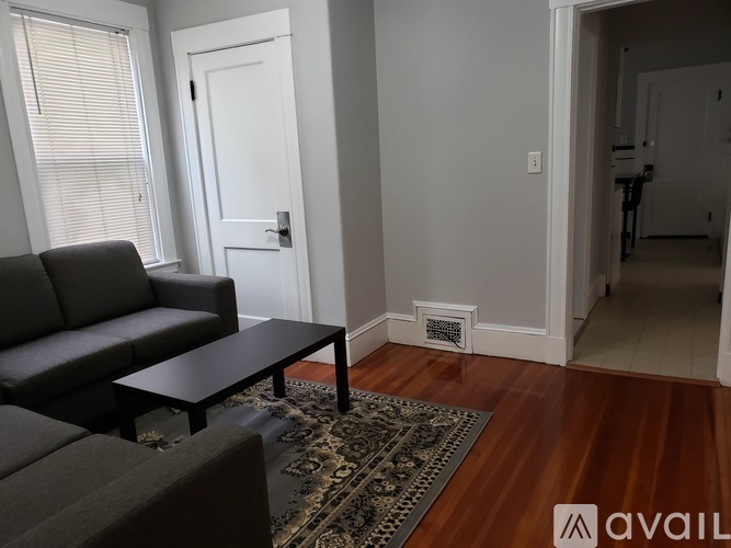 A living room with a black couch and a coffee table.