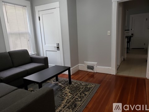 A living room with a black couch and a coffee table.