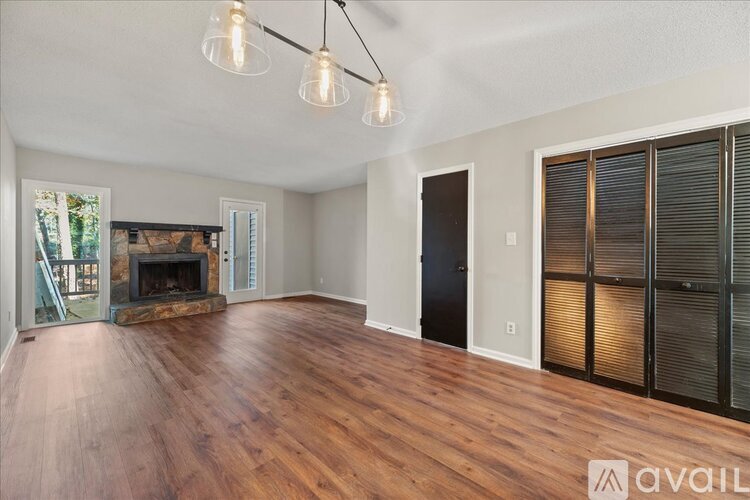 A spacious room with wooden floors and a fireplace.