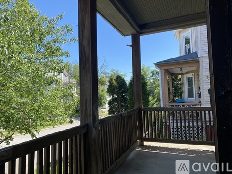 A wooden deck with a view of a house and trees.