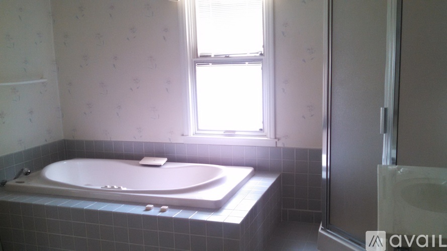 A bathroom with a bathtub and a window.