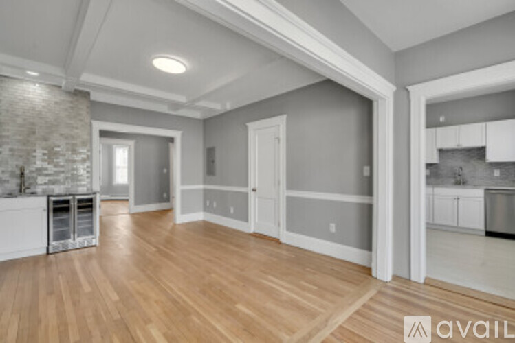 A spacious room with wooden floors and a stone wall.