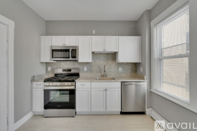 A kitchen with white cabinets and appliances.