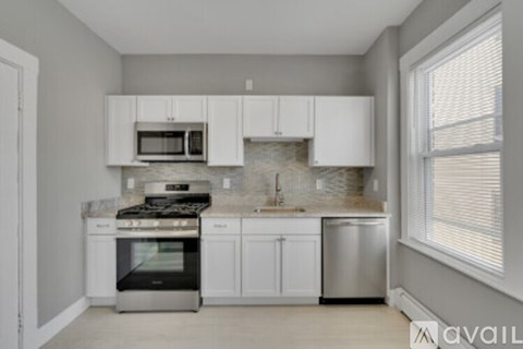 A kitchen with white cabinets and appliances.