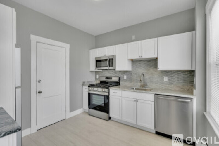 A kitchen with white cabinets and stainless steel appliances.