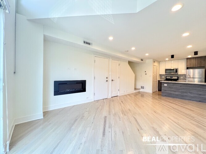 A spacious living room with a fireplace and wooden flooring.