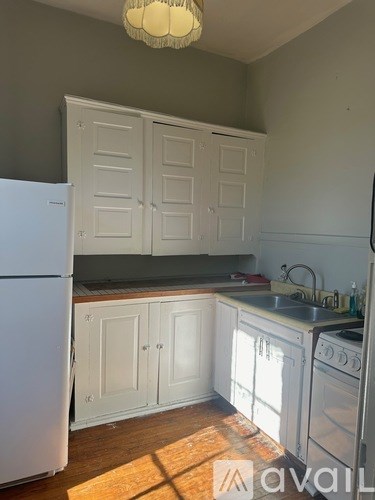A kitchen with white cabinets and a white fridge.