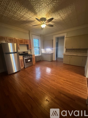 A kitchen with wooden floors and a ceiling fan.