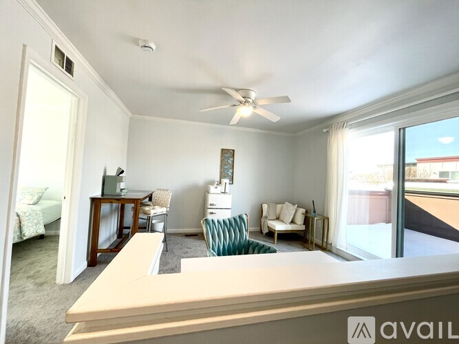 A living room with a couch, chair, and a fan.