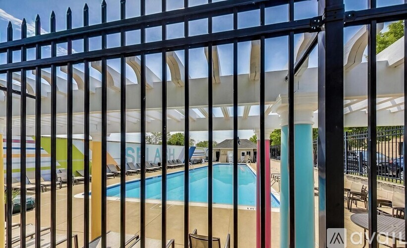 A pool area with a black fence in the foreground.