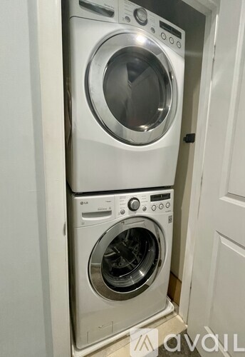 A white washing machine and dryer stacked on top of each other in a small space.